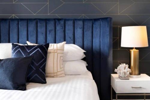 a bedroom with a bed with a blue headboard at Blue Dreams in Sydney