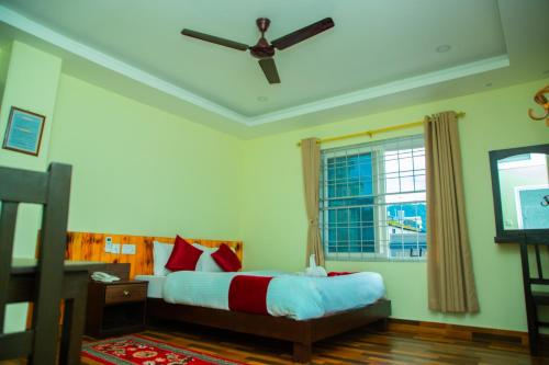 um quarto com uma cama e uma ventoinha de tecto em Hotel Pokhara Suites em Pokhara