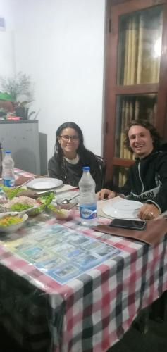 two people sitting at a table with plates of food at Himansa Homestay in Ella