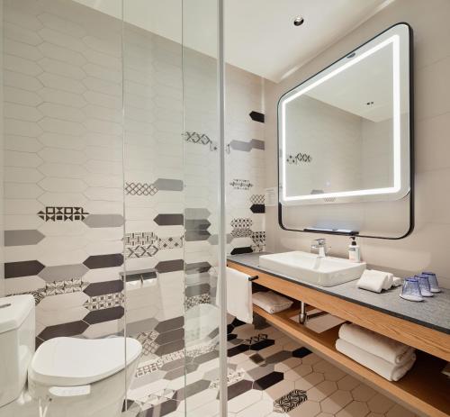 een badkamer met een toilet, een wastafel en een spiegel bij Holiday Inn Express Chiayi, an IHG Hotel in Chiayi City