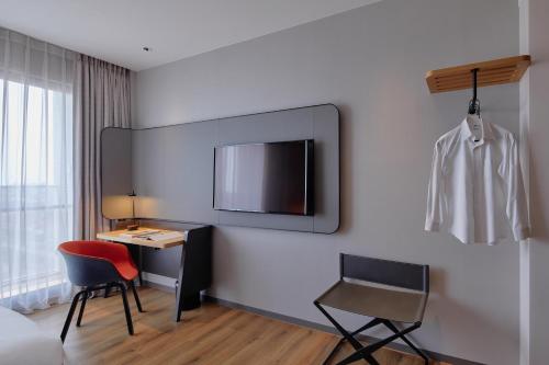 a hotel room with a desk and a tv on the wall at Holiday Inn Express Chiayi by IHG in Chiayi City