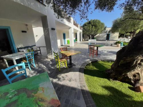 a patio with tables and chairs and a painting at Borgo Rurale Cares in Dorgali
