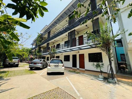 two cars parked in a parking lot in front of a building at Saengcanthr แสงจันทร์ in Ban Nong Chabok