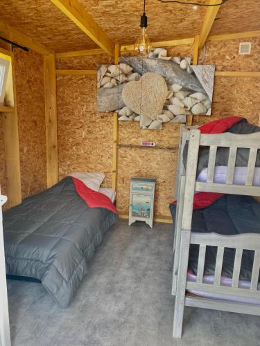 - une chambre avec 2 lits superposés dans une cabane en rondins dans l'établissement CAMPING LES EMBRUNS 3*, à Camoël