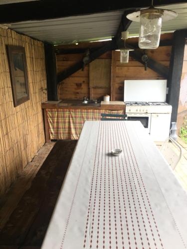 a large white table in a kitchen with a stove at Gîte pura vida in Périssac