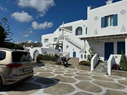 un coche aparcado frente a una casa blanca en Anais en Mykonos ciudad