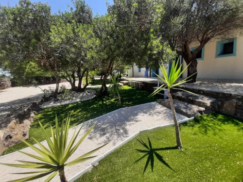 a garden with palm trees and a building at Borgo Rurale Cares in Dorgali