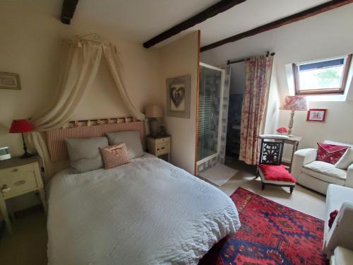 une chambre avec un grand lit blanc et un canapé dans l'établissement LES CHAMBRES DE MIMI, à Vigoux