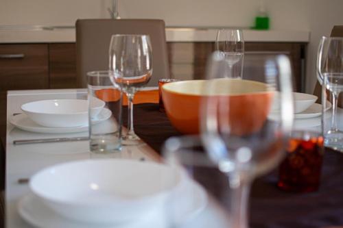 a table with wine glasses and a bowl on it at Fort Chambray Holiday Villas & Apartments in Mġarr