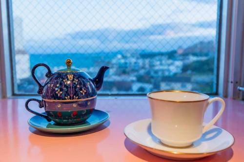 a tea pot and a cup on a table at シートピア恩納村 徒歩3分でビーチへ 6名宿泊可能 空港直通バス停目前で便利 in Fuzuchi