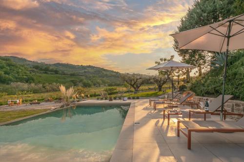a pool with tables and chairs and an umbrella at Panfilo Farmhouse in Cellino Attanasio