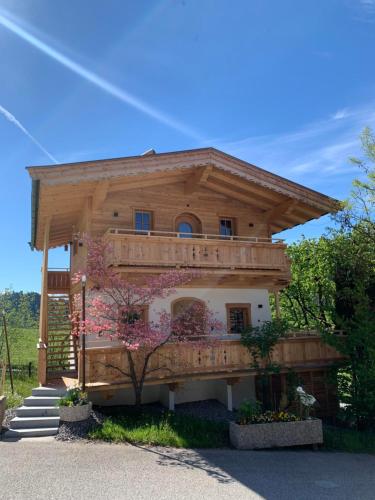 a large wooden house with a balcony and stairs at s'Zuhaus in Kirchbichl