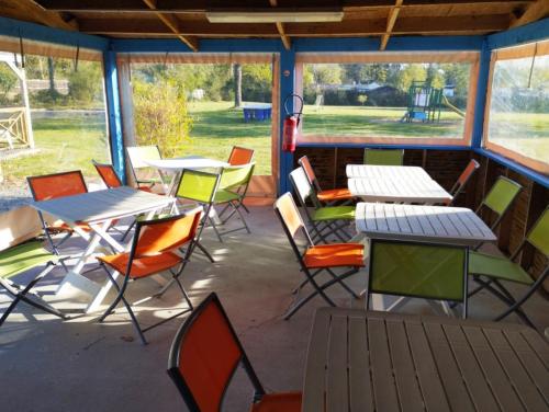 - un ensemble de tables et de chaises sur une terrasse dans l'établissement La haut, à Camoël