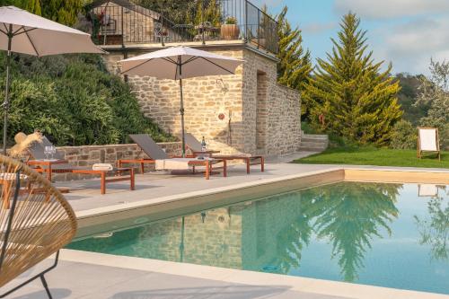 a swimming pool with two chairs and an umbrella at B&B Panfilo Farmhouse in Cellino Attanasio