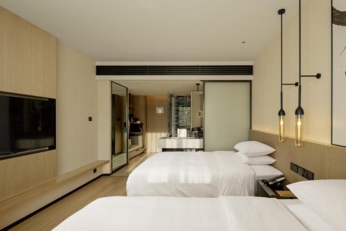 麗江的住宿－丽江古城万枫酒店，一间卧室设有三张床和电视