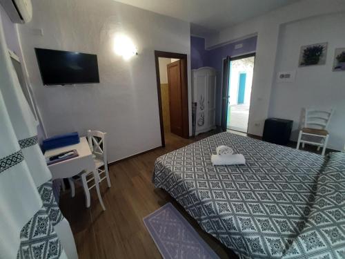 a bedroom with a bed and a table and a television at Borgo Rurale Cares in Dorgali