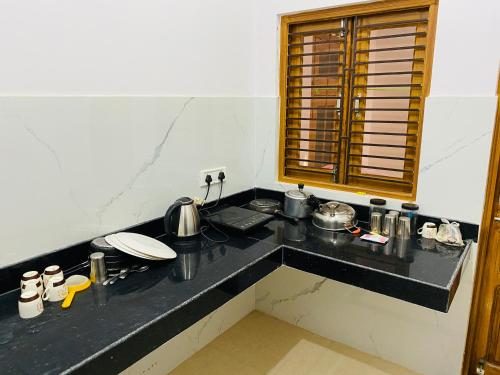 a kitchen with a black counter top with pots and pans at Green View Apartments F1 in Varanasi