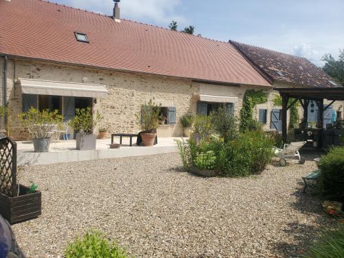 une maison avec une cour ornée de plantes en pot dans l'établissement LES CHAMBRES DE MIMI, à Vigoux