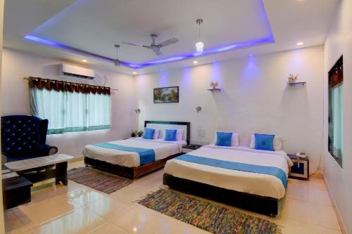a hotel room with two beds and a couch at Hotel Silver Inn in Mahabaleshwar