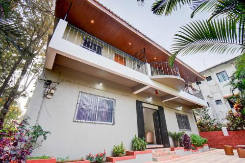 a white house with a balcony on top of it at Hotel Silver Inn in Mahabaleshwar