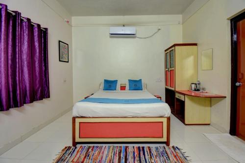a bedroom with a bed and a cabinet and a table at Hotel Silver Inn in Mahabaleshwar