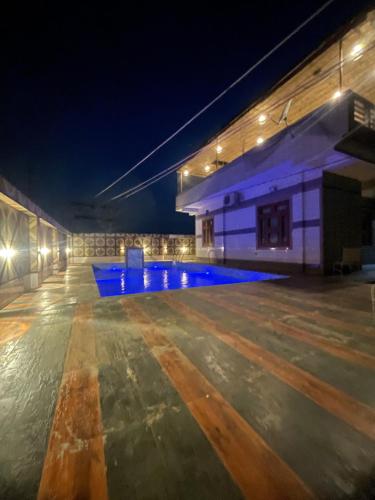 un edificio con piscina por la noche en The hide away home resort en Chonp