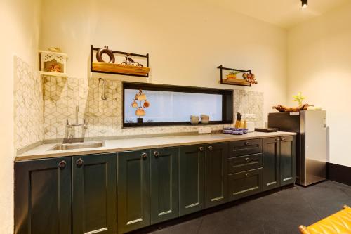 a kitchen with green cabinets and a sink at The Hanging Villa - A Luxury Pool Villa in Jaipur in Jaipur