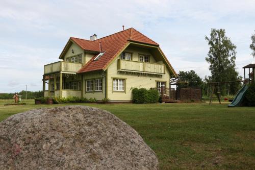 Casa amarilla con techo rojo y parque infantil en Holidayhouse Tolsburg with sauna, en Toolse