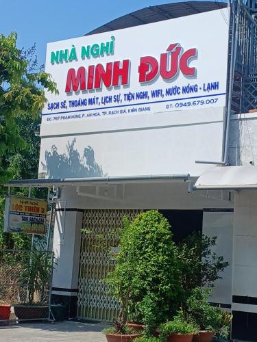 a large sign for a mini bus on a building at Nhà nghỉ Minh Đức in Rạch Giá