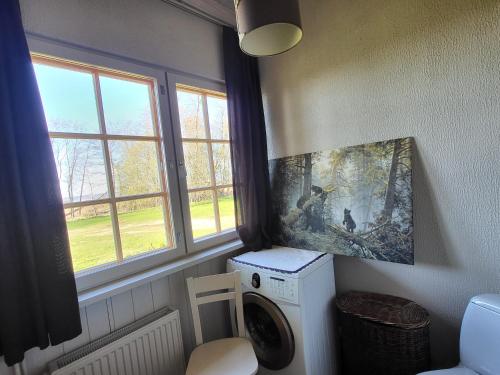 a laundry room with a washing machine and windows at Beach house Tolsburg with sauna in Toolse