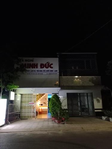 a night photo of a gym dmg sign on a building at Nhà nghỉ Minh Đức in Rạch Giá