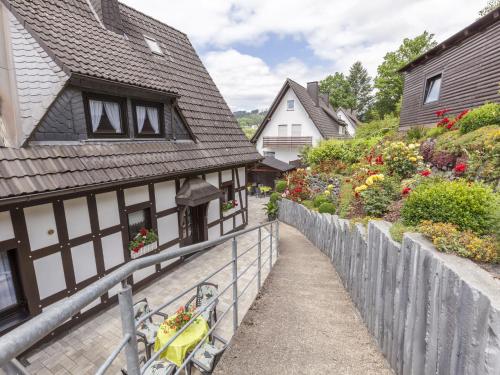 a path in a village with houses and flowers at Cosy apartment in Hallenberg near centre in Hallenberg