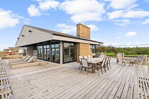 a patio with a table and chairs on a wooden deck at Ptit - 3 bedroom 2 bath Waterfront Oasis in Grand Barachois