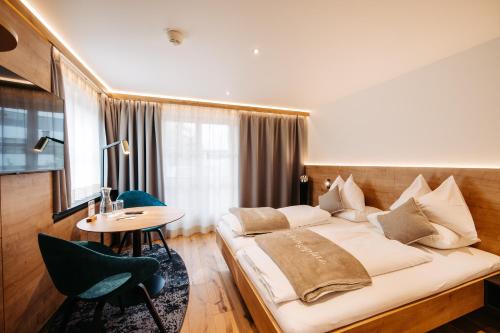 una camera d'albergo con un letto e un tavolo di Sonne 1806 - Hotel am Campus Dornbirn a Dornbirn