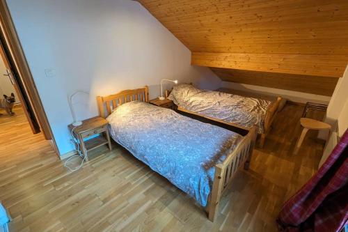 a bedroom with two beds and a wooden ceiling at Thollon Appt 8 pers à 50m a pied du télécabine in Thollon