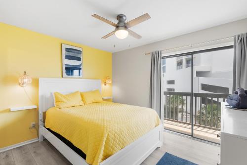 格尔夫海岸Steps to Sand l Ocean views l Smart TVs l Pool的一间卧室设有一张黄色墙壁和窗户的床