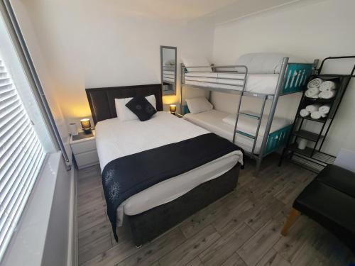 a small bedroom with a bunk bed and a couch at GATWICK ROOMs-TRAVEL SERVICE-AIRPORT PARKING in Ifield