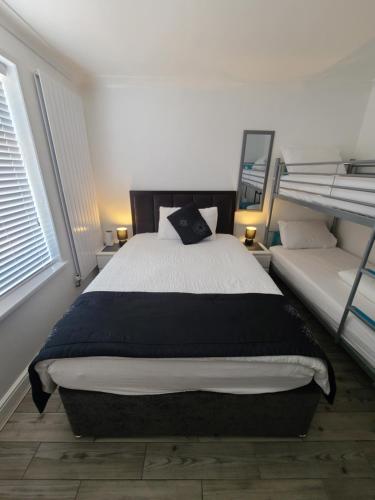 a bedroom with a bed and two bunk beds at GATWICK ROOMs in Ifield