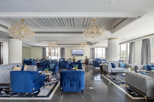 un vestíbulo con sillas azules y lámparas de araña en Luxury Night Hotel en Riad