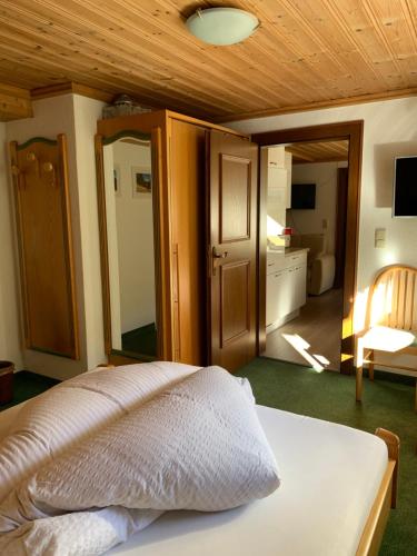 a bedroom with a white bed with a wooden ceiling at Apart Bella Vista - Wohnung und Garni in Kappl