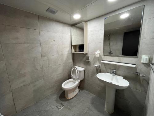 La salle de bains est pourvue de toilettes, d'un lavabo et d'un miroir. dans l'établissement green house room 103, à Séoul