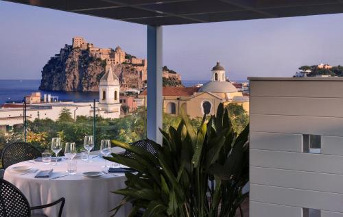 a table with wine glasses and a view of the ocean at Il Lauro Luxury Villa in Ischia