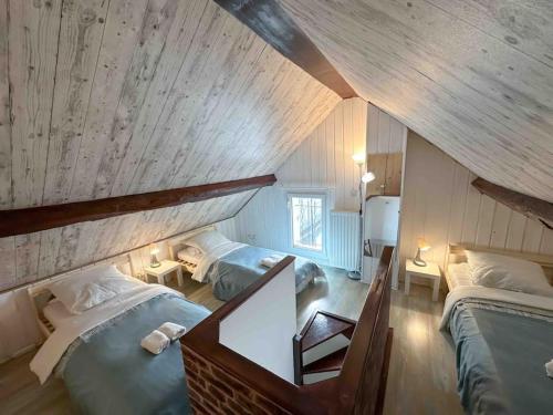 a attic bedroom with two beds in a room at La chaumière de Walt : Petite maison proche Disney in Bussy-Saint-Georges