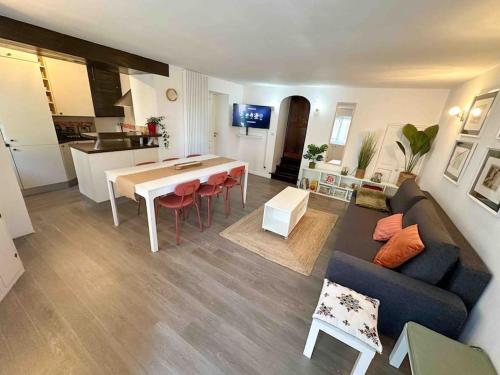 a living room and kitchen with a couch and a table at La chaumière de Walt : Petite maison proche Disney in Bussy-Saint-Georges