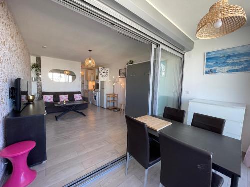 une salle à manger et un salon avec une table et des chaises dans l'établissement STUDIO 2-3 pers PARKING CLIM VUE PORT ET MER, à La Grande Motte