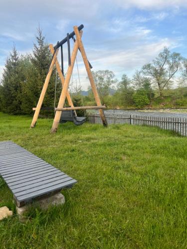 a swing set in a yard with a bench at Shum Cheremosha in Verkhovyna