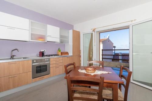 a kitchen with a table and a kitchen with a view at Appartamento bilocale vista mare FT7 in Cascabraga