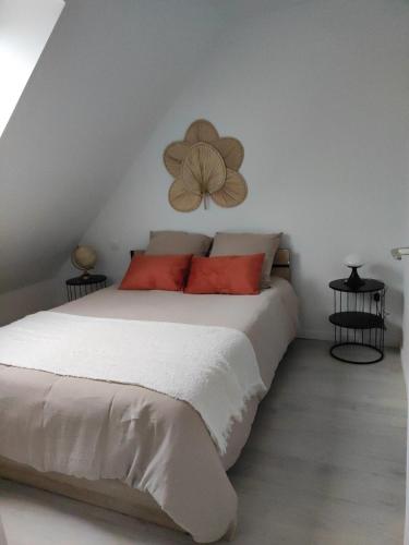 une chambre avec un lit blanc avec des oreillers rouges dans l'établissement Le Ptit Normand entre Ville & Plages, à Loucelles