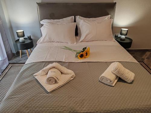 Una cama con toallas y un ramo de flores. en VICTORIA HOUSE, en Kavala