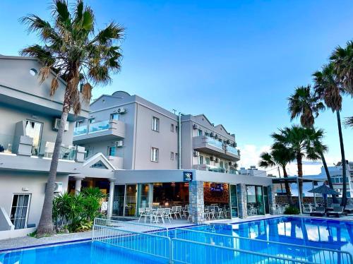 a hotel with a swimming pool in front of a building at Argiri Resort Hotel & Apartments in Kardamaina